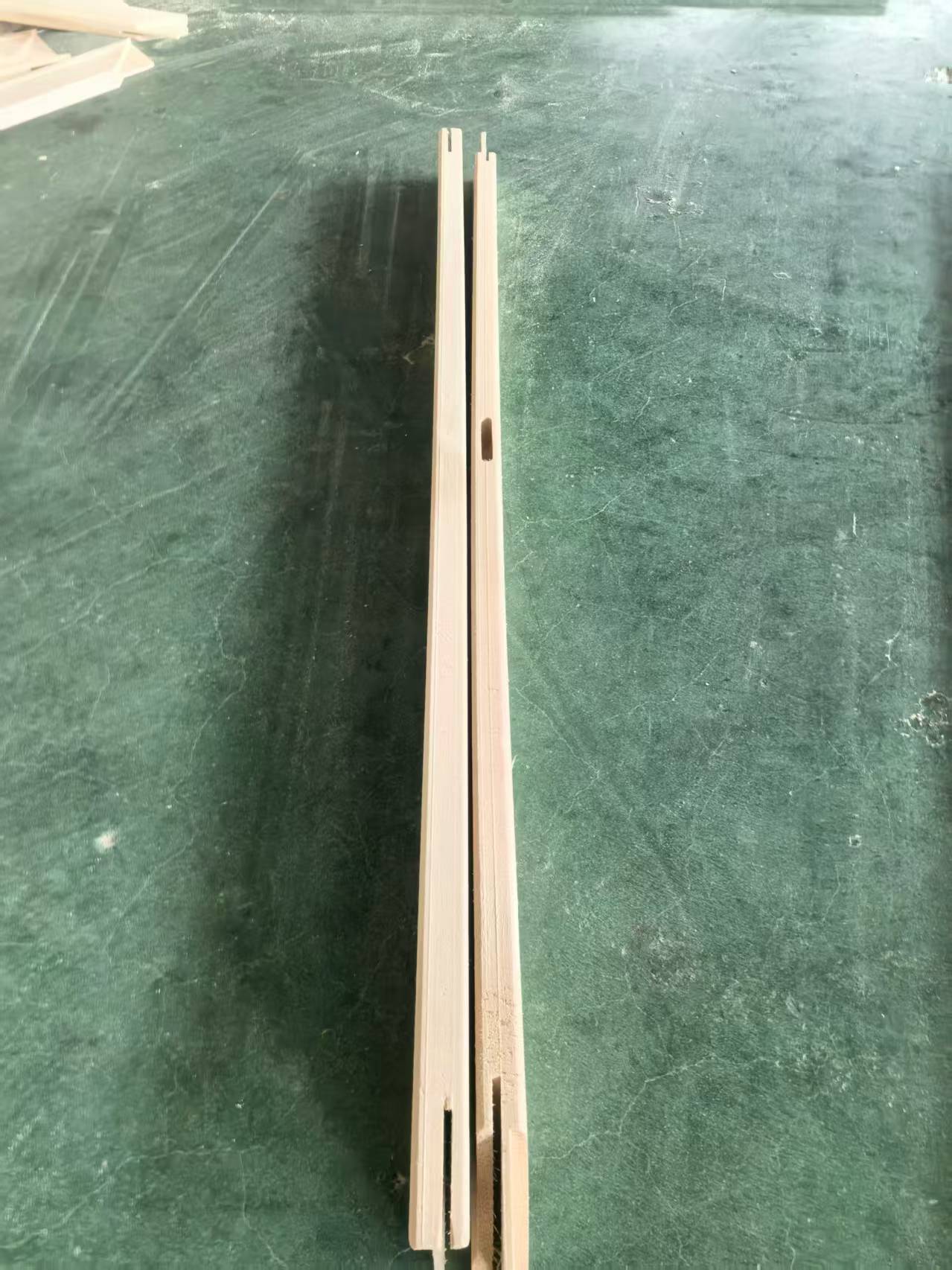 Pine wooden stretcher bars showing different straightness and warping conditions during factory inspection